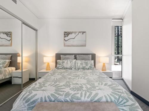 a bedroom with a large bed and two lamps at City Centre Apartment New Furnitures in Brisbane
