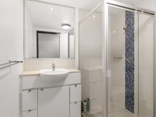 a white bathroom with a sink and a shower at City Centre Apartment New Furnitures in Brisbane
