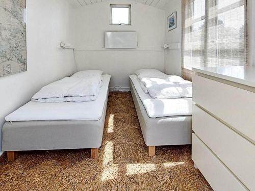 2 Betten in einem kleinen Zimmer mit Fenster in der Unterkunft Holiday home Karrebæksminde IX in Karrebæksminde