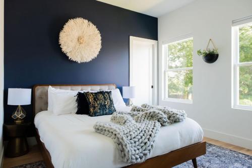 een slaapkamer met een groot bed met een blauwe muur bij The Adelaide - Downtown Luxury & Charming Rooftop in Nashville