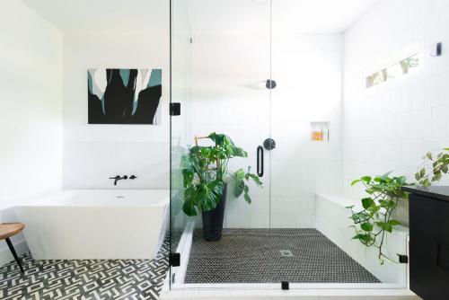 een badkamer met een bad en een douche met een plant bij The Adelaide - Downtown Luxury & Charming Rooftop in Nashville