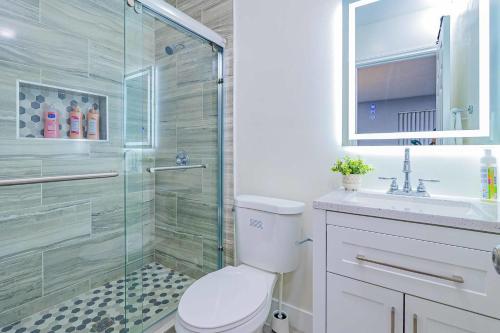 uma casa de banho com um chuveiro, um WC e um lavatório. em Newly Remodeled 2B2B Apartment in Altadena em Pasadena
