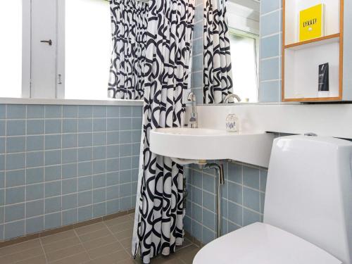a bathroom with a sink and a shower curtain at Holiday home Aabenraa LXXI in Aabenraa