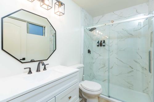 uma casa de banho com um chuveiro, um WC e um espelho. em Newly Remodeled 5B4B 2 mile from the Rose Parade em Pasadena