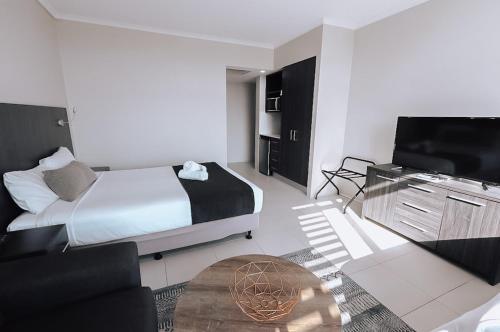 a bedroom with a bed and a flat screen tv at Alivio Hotel Cairns in Cairns