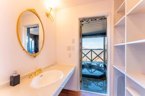 a bathroom with a sink and a mirror at Noёl HAKONE GENSEN in Hakone