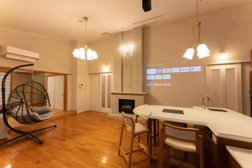 a kitchen with a table and chairs and a fireplace at Noёl HAKONE GENSEN in Hakone