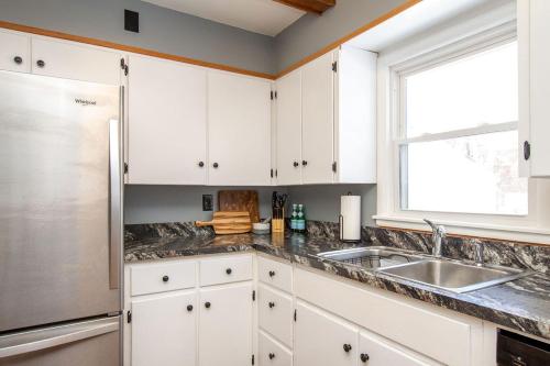 a kitchen with white cabinets and a sink and a window at NEW Charming Home in the Heart of North Fargo in Fargo