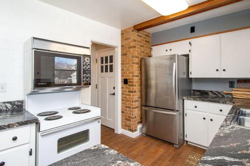 a kitchen with white cabinets and a stainless steel refrigerator at NEW Charming Home in the Heart of North Fargo in Fargo