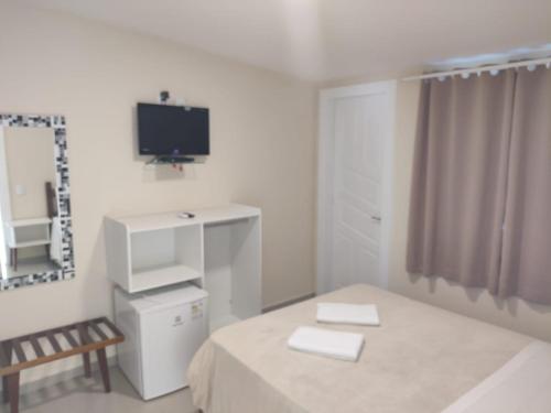 een witte kamer met een bed en een spiegel bij Sonho 2 Guest House in Búzios