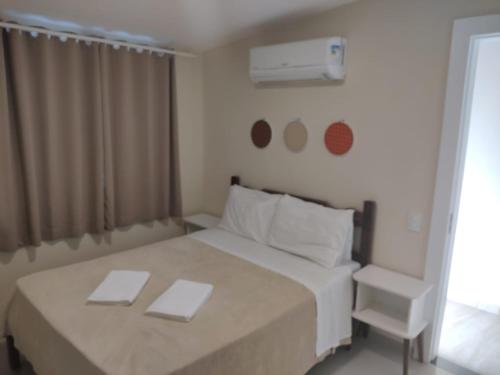 a bedroom with a white bed and a chair at Sonho 2 Guest House in Búzios