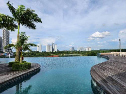 a swimming pool with palm trees and a city at Macrolink Medini Legoland by Stayrene in Kangkar Pendas