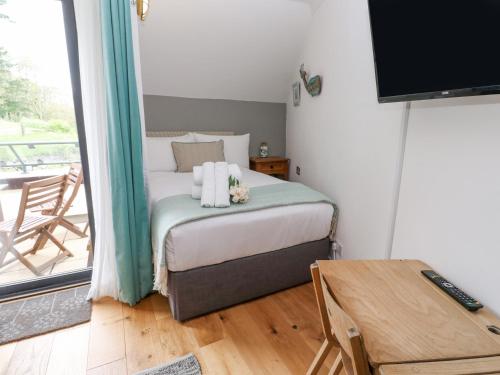 a bedroom with a bed with towels and a balcony at The Crows Nest in Falmouth