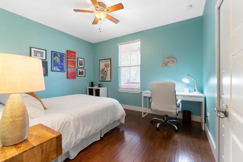a bedroom with blue walls and a bed and a desk at Fullerwood Delight- Mins to Beach and Downtown in St. Augustine
