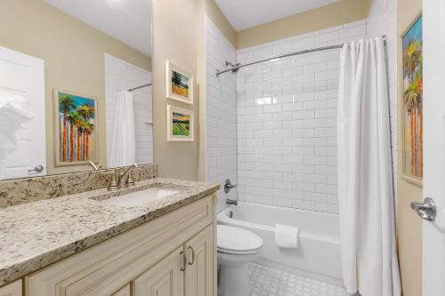 a bathroom with a sink and a toilet and a tub at Fullerwood Delight- Mins to Beach and Downtown in St. Augustine