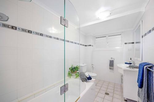 a bathroom with a shower and a toilet and a sink at Allure By The Sea in Bonny Hills