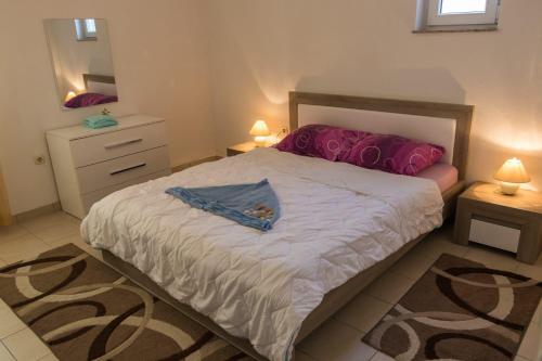 a bedroom with a large bed and a mirror at Apartments Zeljka B in Mundanije