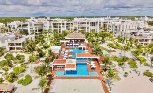 坎昆的住宿－Departamento de lujo con playa y marina en Cancun-La Amada，享有带游泳池的度假村的空中景致