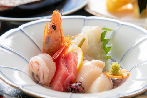 a plate of food with seafood on a table at Tsukasa Ryokan in Saga
