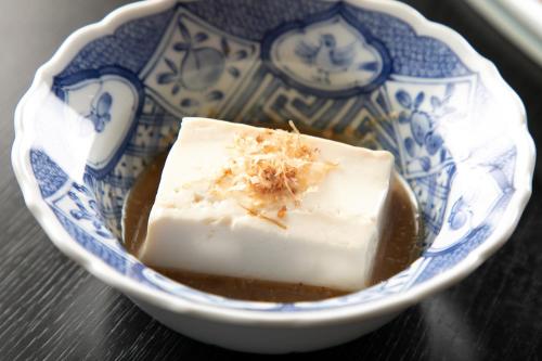 a blue and white bowl with a piece of food in it at Tsukasa Ryokan in Saga