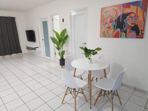 a dining room with a white table and chairs at San Juan Apartments in San Juan