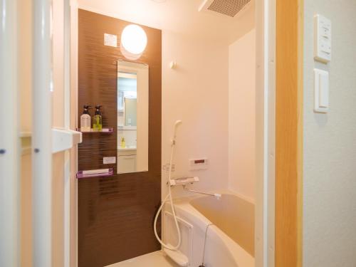 uma casa de banho com um WC e um espelho. em DC桜の苑401洋式双人床 em Osaka