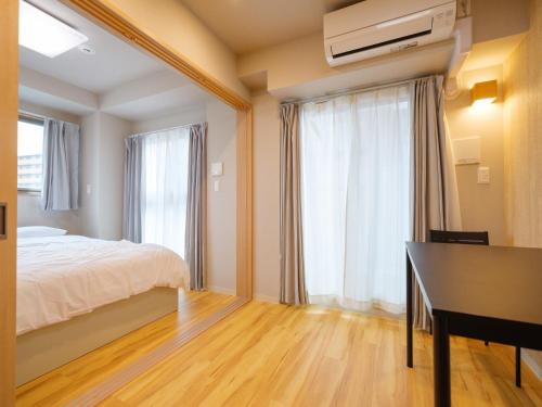 DC桜の苑401洋式双人床 في أوساكا: غرفة نوم بسرير ومكتب ونافذة