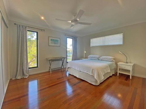 una camera da letto con un letto e un tavolo su un pavimento in legno di ANNIES HOUSE ad Amity Point
