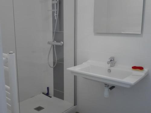 une salle de bain blanche avec un lavabo et une douche dans l'établissement T2 tout confort proche plage, 4 pers, ascenseur - FR-1-331-77, à Les Sables-dʼOlonne
