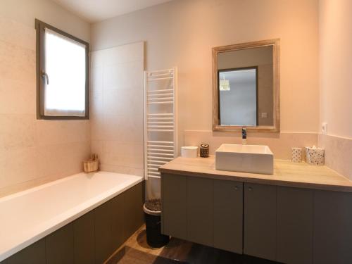 a bathroom with a sink and a bath tub and a mirror at Villa Sainte-Marie-de-Ré, 5 pièces, 8 personnes - FR-1-258-76 in Sainte-Marie-de-Ré