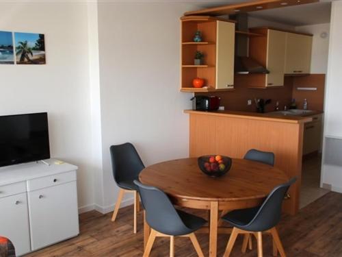 eine Küche und ein Esszimmer mit einem Holztisch und Stühlen in der Unterkunft Appartement Les Sables-d'Olonne, 2 pièces, 4 personnes - FR-1-331-84 in Les Sables-dʼOlonne