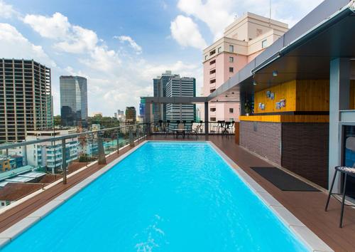 a large swimming pool on the roof of a building at RAMADA ENCORE BY WYNDHAM SAIGON D1 - Formerly M Boutique Hotel Saigon in Ho Chi Minh City