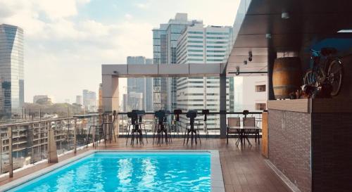 a balcony with a swimming pool on top of a building at RAMADA ENCORE BY WYNDHAM SAIGON D1 - Formerly M Boutique Hotel Saigon in Ho Chi Minh City