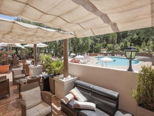 une terrasse meublée et une piscine dans l'établissement Grimaud : Appartement 3 Pces avec piscine et vue mer - FR-1-226-514, à Grimaud