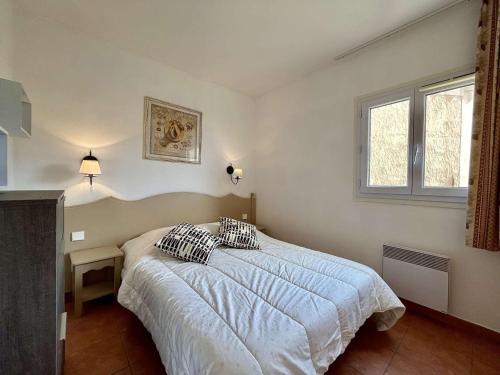 um quarto com uma cama e uma janela em Appartement Les Issambres, 2 pièces, 5 personnes - FR-1-226-516 em Roquebrune-sur-Argens