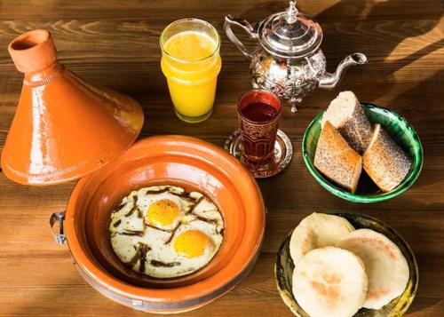 an orange bowl of eggs and bread on a table at Oujda appart in Oujda