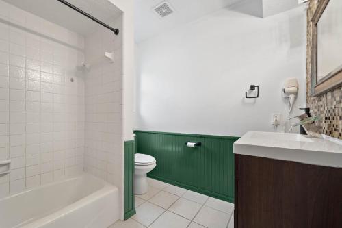 a bathroom with a toilet and a green wall at The Pines I Sleeps 12 I Private Pool I Patio & BBQ in Conroe