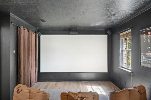 a room with a large white screen on the wall at The Pines I Sleeps 12 I Private Pool I Patio & BBQ in Conroe