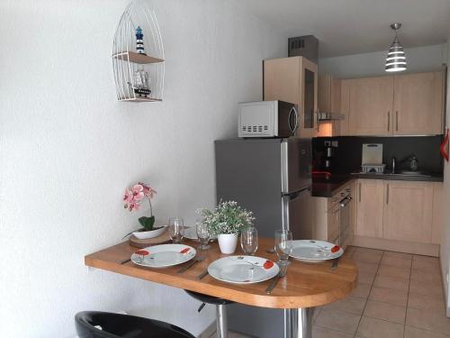 une cuisine avec une table en bois et des plaques de cuisson. dans l'établissement Appartement charmant avec balcon, proche centre de Capbreton, parking inclus - FR-1-239-941, à Capbreton