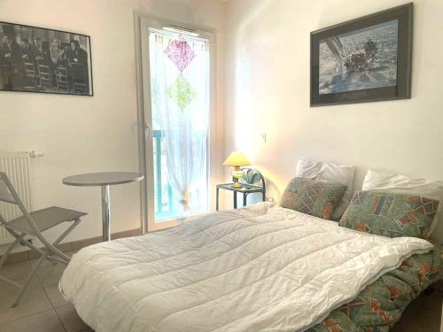 a bedroom with a bed and a table and a window at Appartement Confortable à Soorts-Hossegor avec Terrasse, Parking et Wifi Inclus - FR-1-239-944 in Soorts-Hossegor