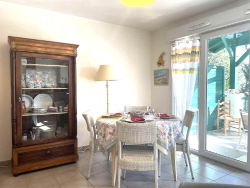 une salle à manger avec une table, des chaises et un psychiar dans l'établissement Appartement Confortable à Soorts-Hossegor avec Terrasse, Parking et Wifi Inclus - FR-1-239-944, à Soorts-Hossegor