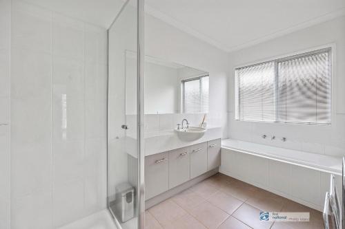 a white bathroom with a sink and a shower at Smiths Beach Walk in Smiths Beach