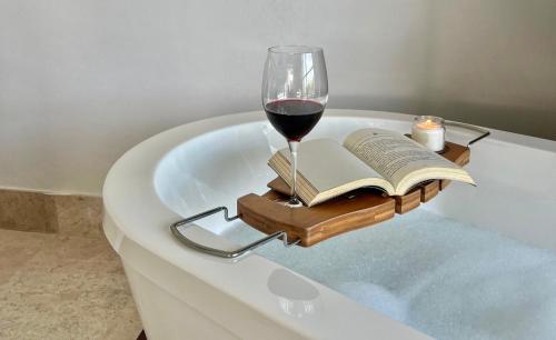 a glass of wine and a book on a bath tub at Departamento de lujo con playa y marina en Cancun-La Amada in Cancún