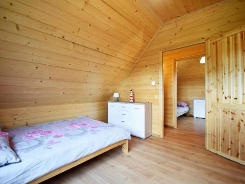 a bedroom with a bed in a wooden room at Comfortable holiday homes for 7 people, Niechorze in Niechorze