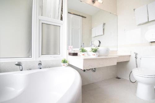 a white bathroom with a toilet and a sink at Bin Bin Hotel 6 - Near SECC D7 in Ho Chi Minh City