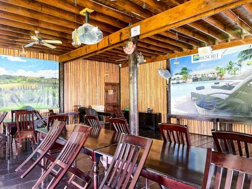 BoscobelにあるOceanside Villa @ Ocho Rios, Jamaica Getawayの木製のテーブルと椅子、大画面のレストランを併設しています。
