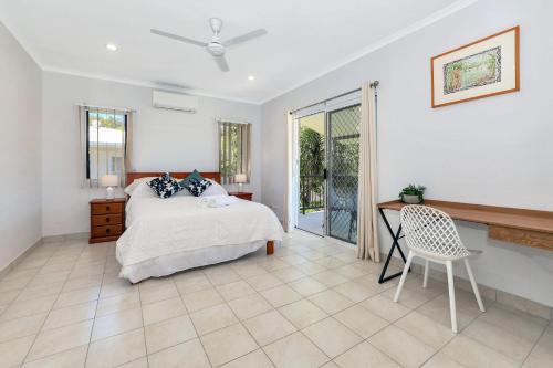 a bedroom with a bed and a desk and a chair at OFFLINE - Charming 3BR Retreat in Central Location of Darwin in Stuart Park
