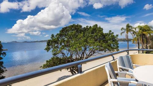 a balcony with chairs and a view of the water at Soldiers Point Absolute Waterfront The Peninsula in Soldiers Point