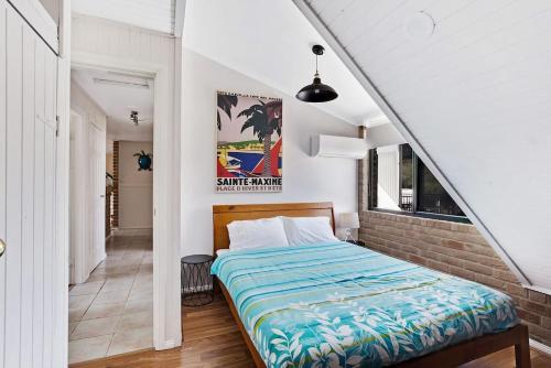a bedroom with a bed and a brick wall at Salt Wood Cabin Style Retreat in Anna Bay