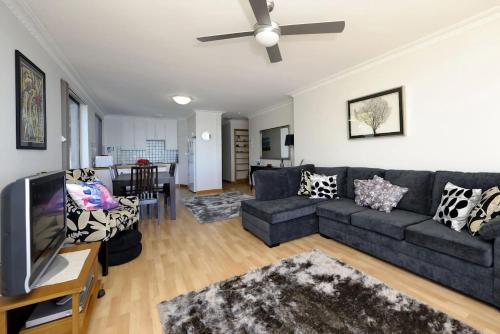 a living room with a couch and a tv at Gorgeous Harbourside in Soldiers Point